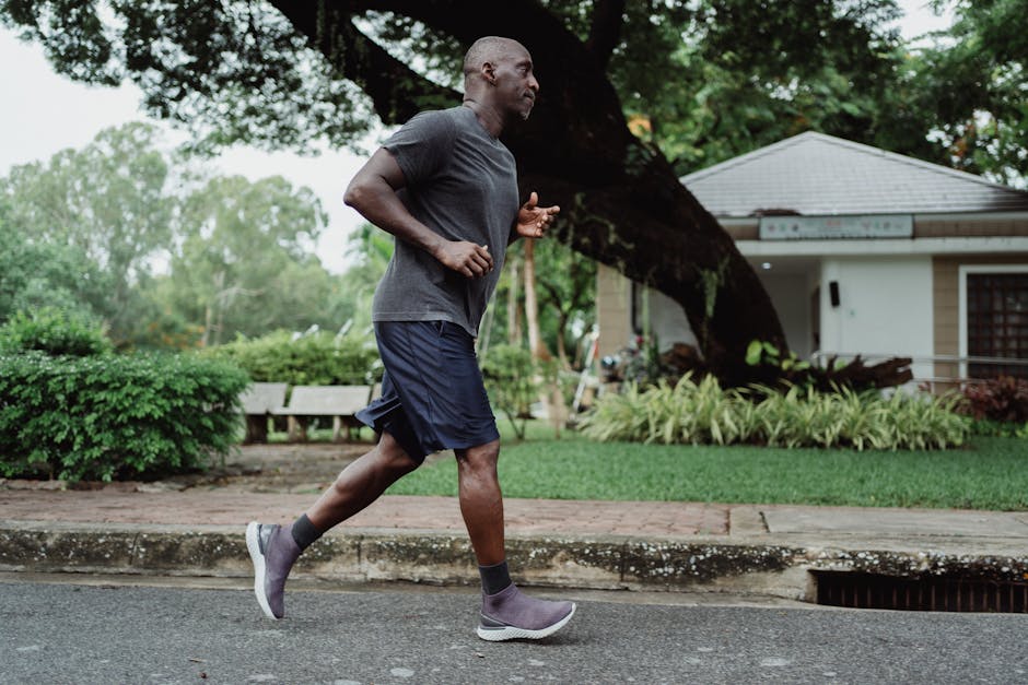 Black man jogging in park, promoting fitness and wellbeing.