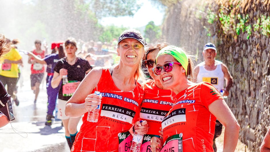 Cheerful female runners smiling during a lively marathon race outdoors.